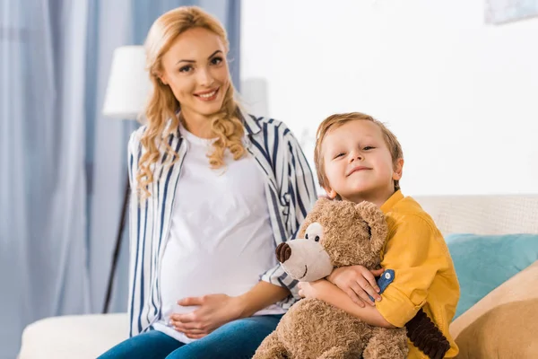 Happy Těhotná Matka Dotýká Břicho Syn Objímání Medvídek — Stock fotografie