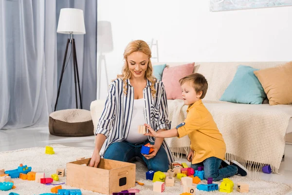 Filho Mostrando Cubo Madeira Mãe Sorridente — Fotografia de Stock