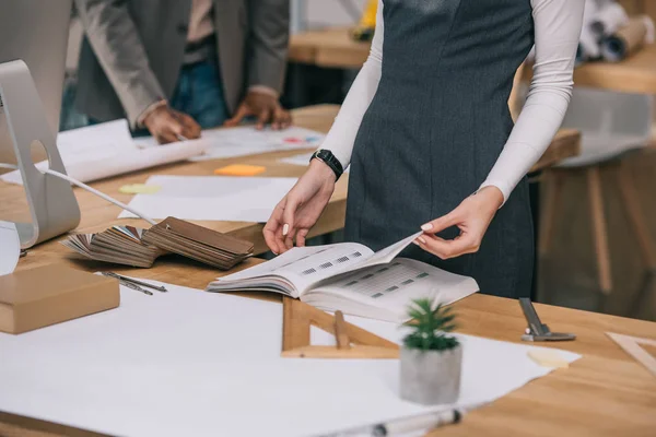 Cropped View Architect Reading Book Workplace Wooden Samples — Stock Photo, Image