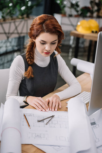young beautiful businesswoman sitting  looking at papers on table