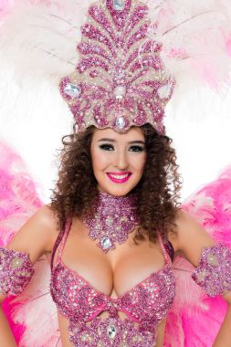 gülümseyen kadın pembe tüyler ve taşlar ile karnaval kılık poz, üzerinde beyaz izole
