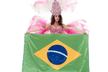 Bright woman in carnival costume with pink feathers holds large flag of Brasil isolated on white clipart