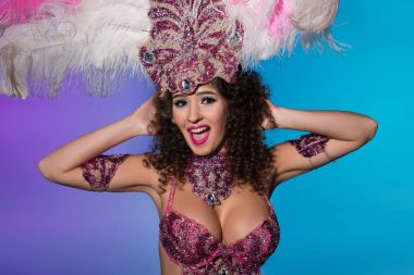 Mutlu genç kadın pembe tüylü izole üzerinde mavi arka plan gülmekten karnaval kılık