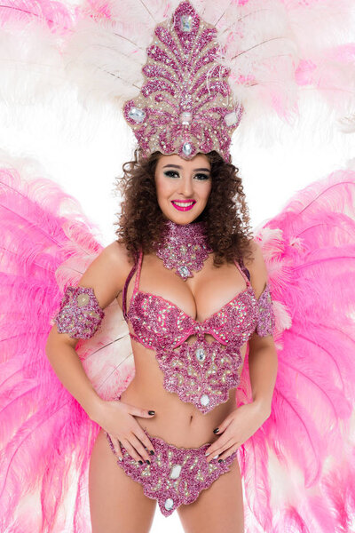 happy woman posing in carnival costume with pink feathers and gems, isolated on white