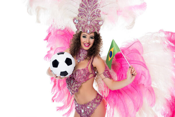 smiling woman in carnival costume holding football ball and brazilian flag while looking at camera, isolated on white    