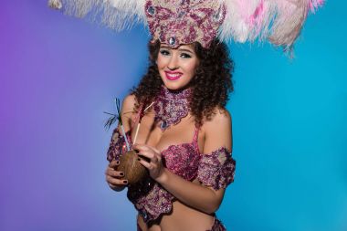 Pembe Tüylü bütün Hindistan cevizi üzerinde mavi arka plan izole içme karnaval kılık neşeli kadın