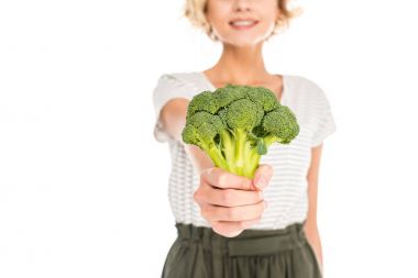 close-up view of young woman holding fresh raw broccoli isolated on white clipart