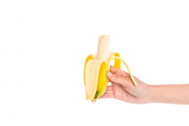 cropped shot of woman holding fresh banana in hand isolated on white clipart