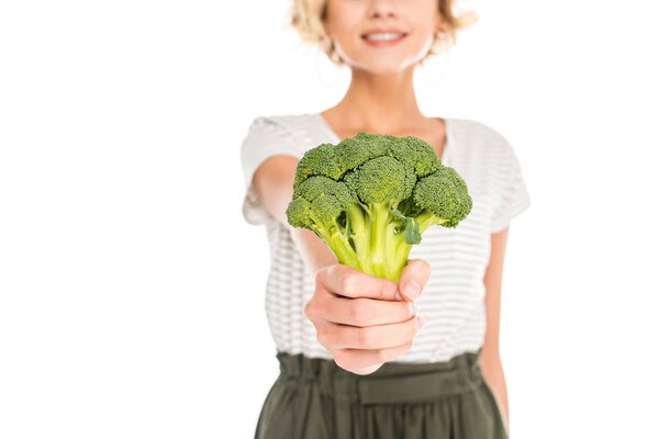 close-up view of young woman holding fresh raw broccoli isolated on white