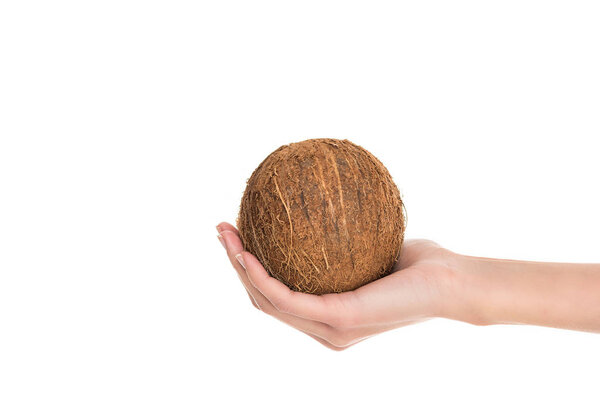 partial view of woman holding coconut in hand isolated on white