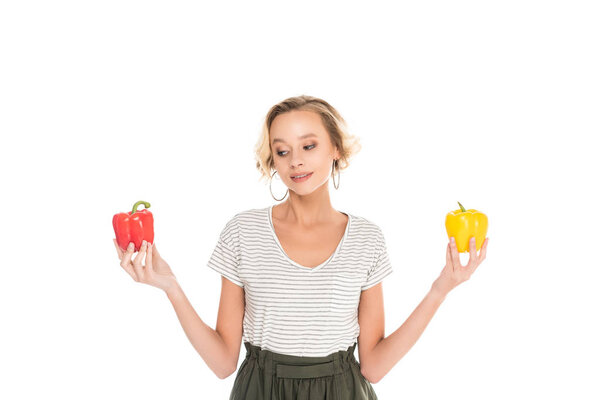 portrait of woman holding fresh bell peppers in hands isolated on white