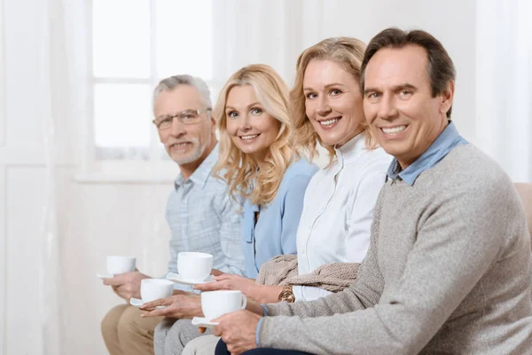 Hombres Mujeres Mediana Edad Conversando Mientras Beben Sofá Mirando Cámara — Foto de Stock