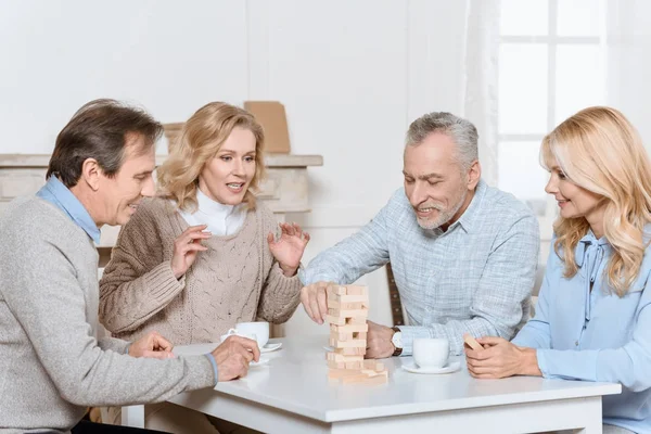 Amigos Felices Sentados Mesa Con Jugando Torre Juego — Foto de Stock