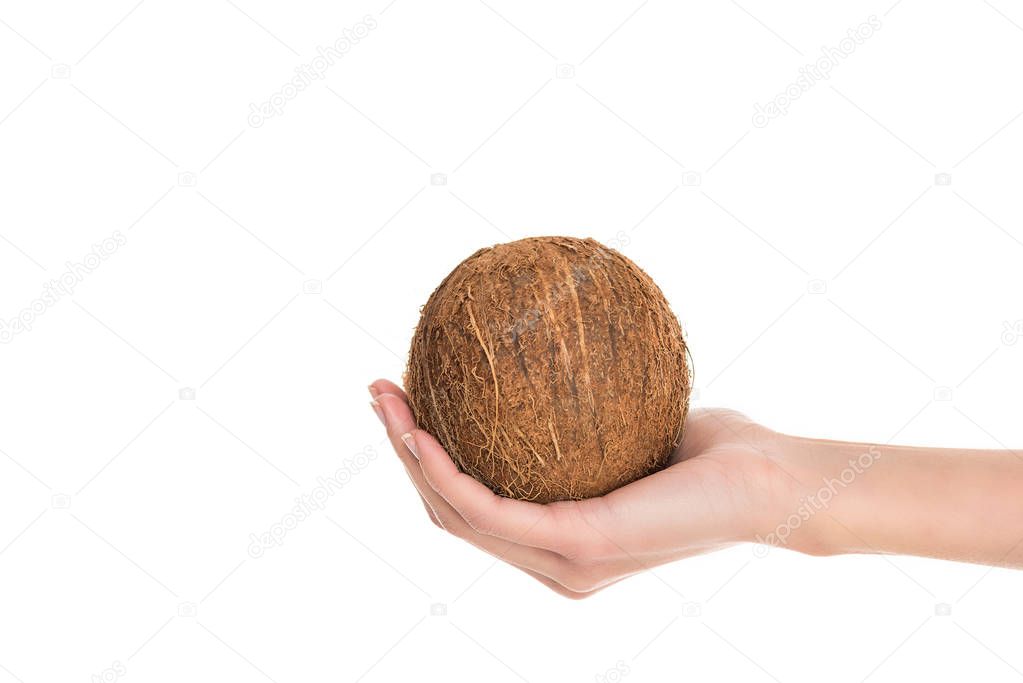 partial view of woman holding coconut in hand isolated on white