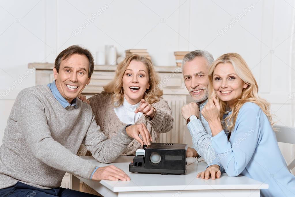 friends sitting at table while using projector on table  