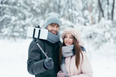 Çift selfie birlikte smartphone kış Park alarak gülümseyen seçici odak