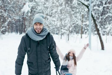 Genç çift birlikte kış gününde parkta sledging