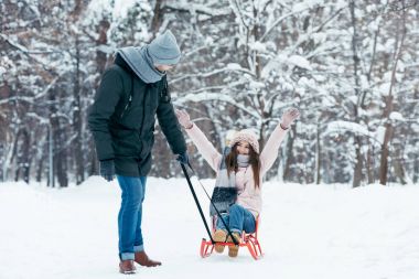 Genç çift birlikte kış gününde parkta sledging