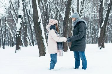 Genç çift birbirine kış ormandaki dururken bakarak