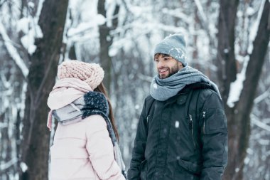 Genç çift birbirine kış ormandaki dururken bakarak