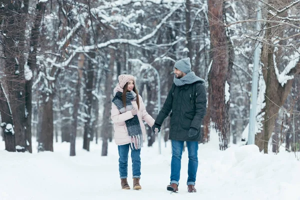 Junges Lächelndes Paar Hält Händchen Und Geht Winterpark Spazieren — Stockfoto