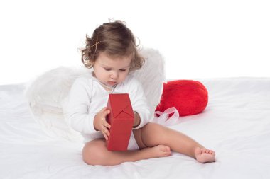 yatakta, üzerinde beyaz izole hediye tutan kanatlı küçük melek yüzlü