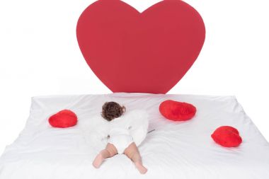 beyaz izole yürekleri yatakta yatarken kanatlı küçük aşk tanrısı