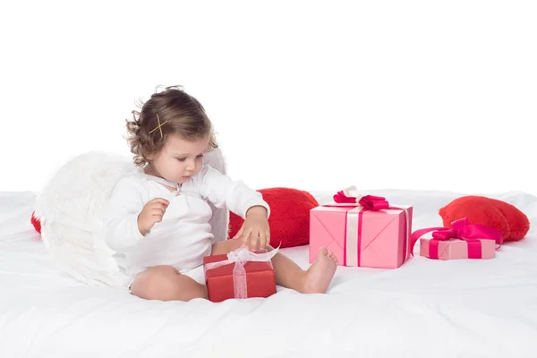 小天使坐在床上的礼品盒 孤立的白色 — 图库照片