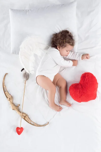 Lilla Bebis Med Vingar Liggande Sängen Med Hjärtat Kudde Pil — Stockfoto