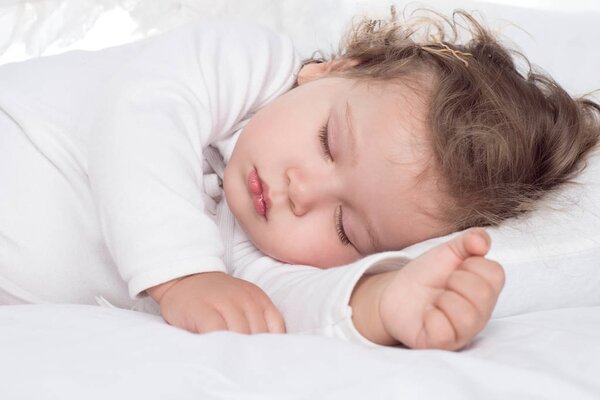 little adorable baby girl sleeping on bed
