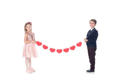 Kırmızı kalpler tutarak ve üzerinde beyaz izole kamera gülümseyen güzel mutlu çocuklar 