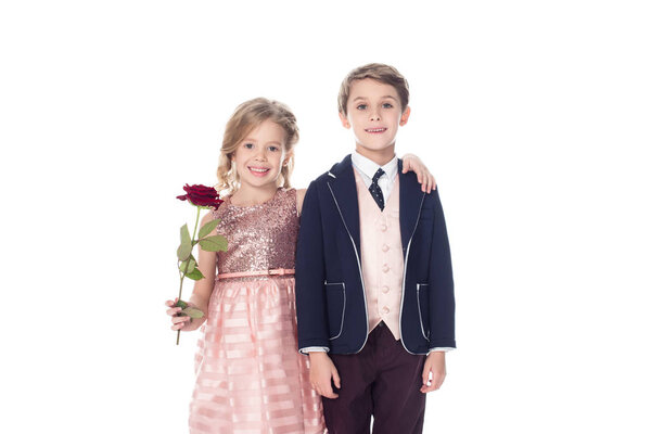 beautiful little kids embracing and smiling at camera while girl holding rose flower isolated on white 