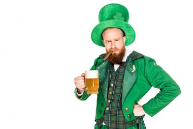 Yeşil kostüm holding puro ve bardak bira üzerinde beyaz izole sakallı adam