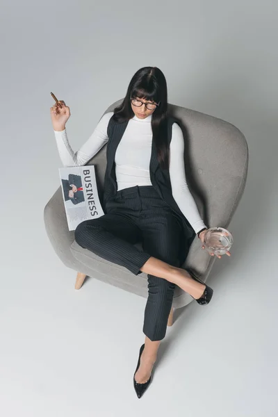 女实业家在灰色扶手椅上吸烟的看法 — 免费的图库照片