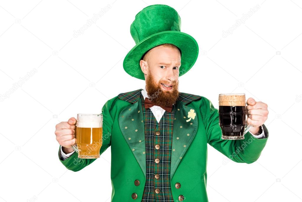 bearded man in green costume and hat holding glasses of beer and looking at camera isolated on white 