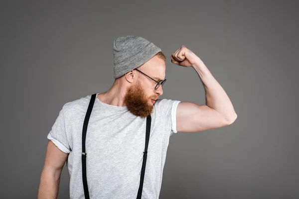 Elegante Uomo Barbuto Bretelle Cappello Guardando Bicipiti Isolati Grigio — Foto stock gratuita