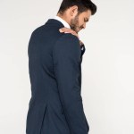 Back view of young businessman suffering from ache in shoulder isolated on grey