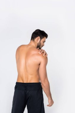 arkadan görünüşü üzerinde beyaz izole omuz ağrısı ile genç gömleksiz adam