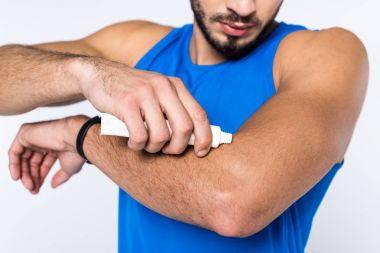 cropped shot of man applying ointment on arm clipart
