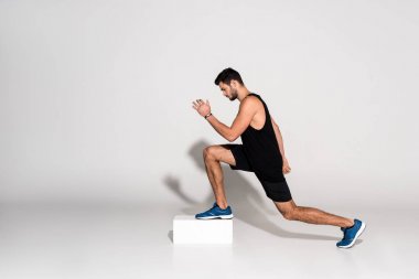 step aerobik blokta yapan atletik erkek yan görünüm