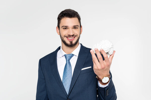 young businessman holding brain model and smiling at camera isolated on grey