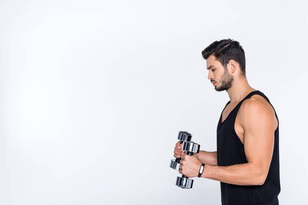 side view of athletic man working out with dumbbells isolated on white