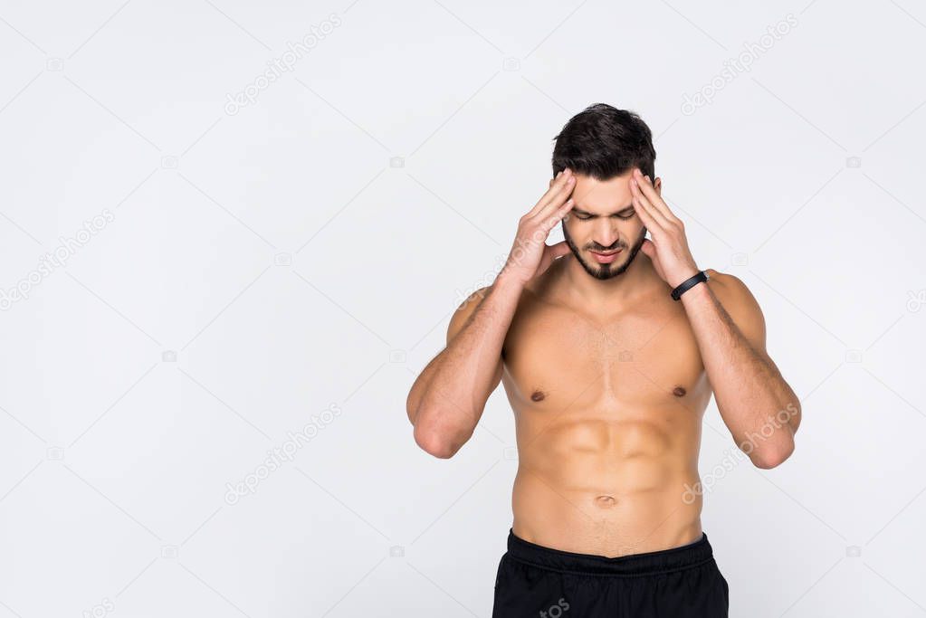 shirtless young sportive man with headache isolated on white