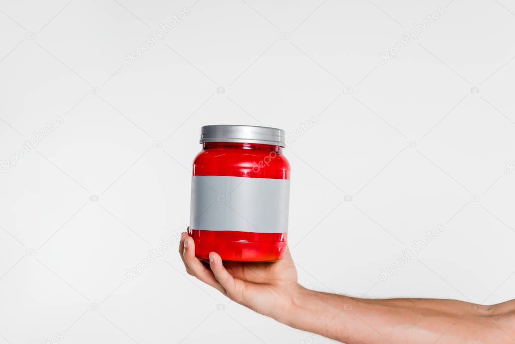 cropped shot of man holding sport supplement jar isolated on white