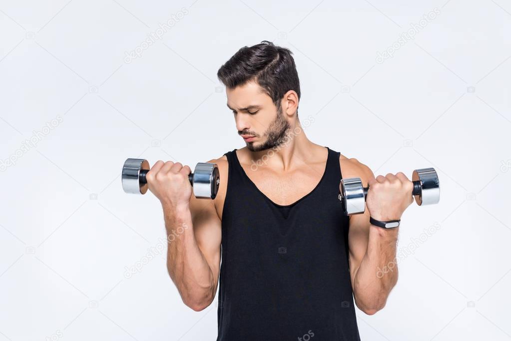 handsome young man working out with dumbbells isolated on white