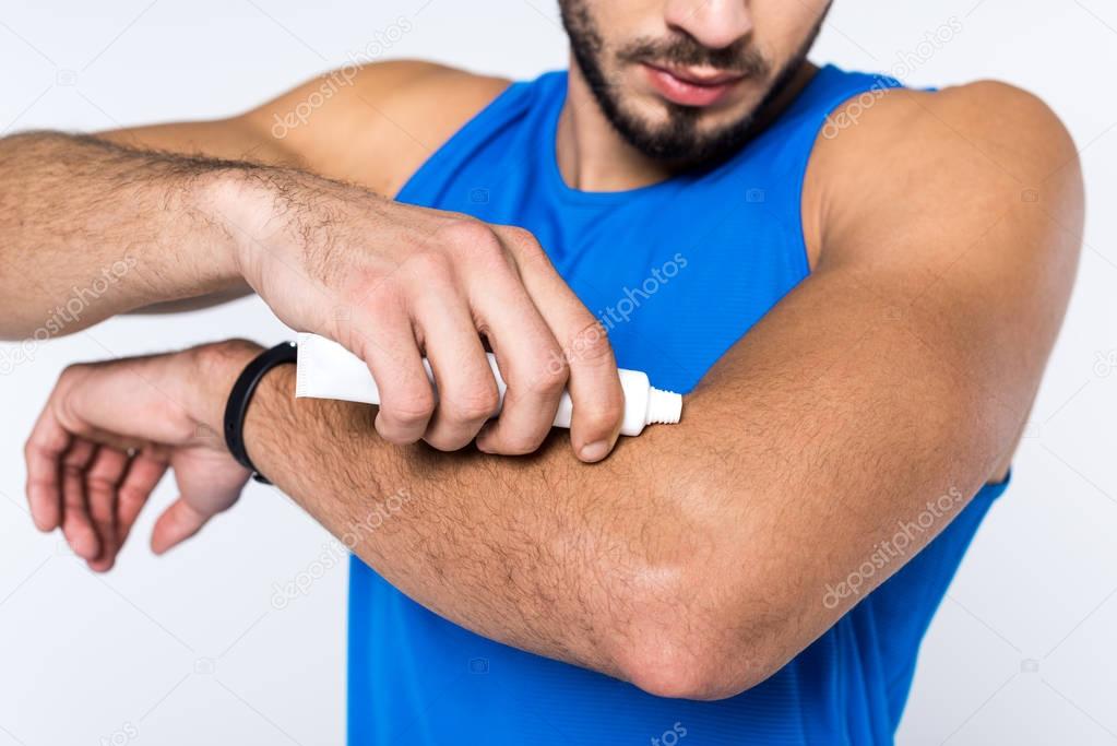 cropped shot of man applying ointment on arm