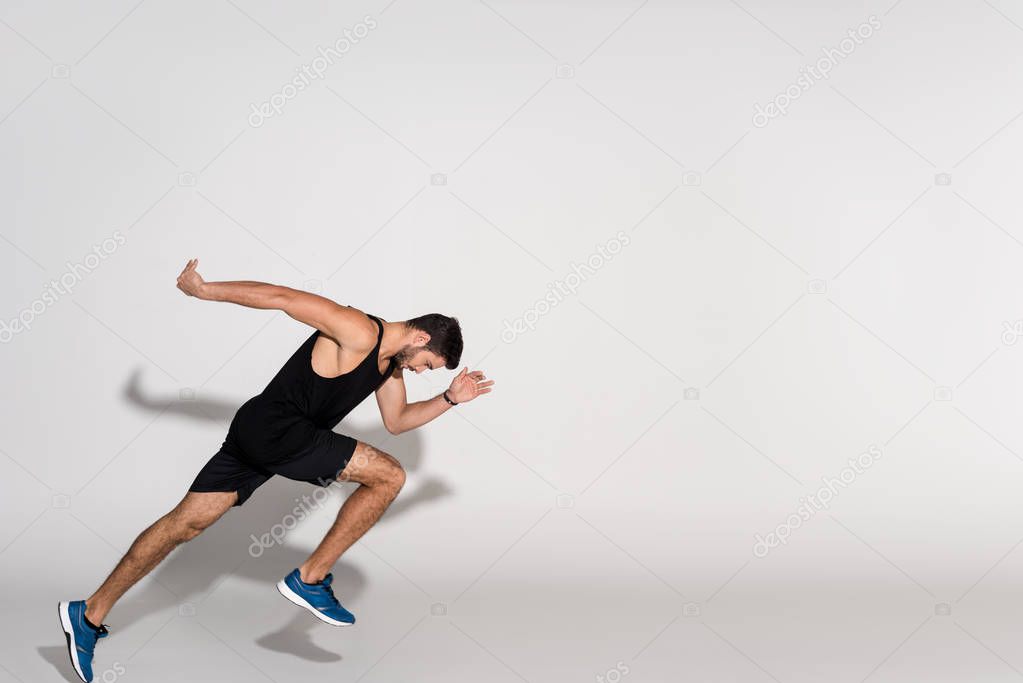 side view of young man running on white