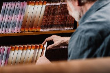 gri saç kütüphaneci alarak kitap raf 