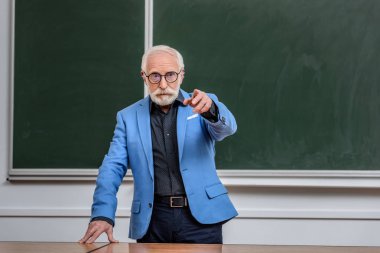Konferans odasında bir şey üzerinde işaret eden öğretim görevlisi