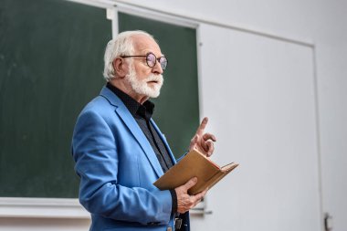 kitap ve gösteren bir parmak dayanabiliyor öğretim görevlisi